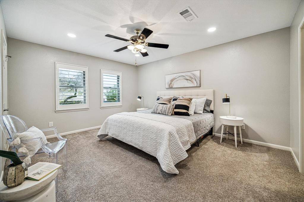 The generously sized primary suite features a walk-in closet, ensuite bath, LED recessed lights, a ceiling fan and two windows with plantation shutters.