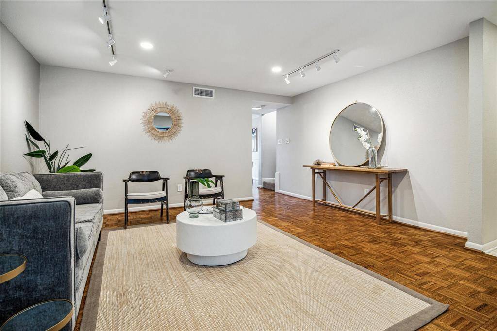 Upon entry, you're welcomed by a spacious living room boasting two large windows with courtyard views, hand laid wood parquet floors, modern LED recessed lighting, and accent picture lighting