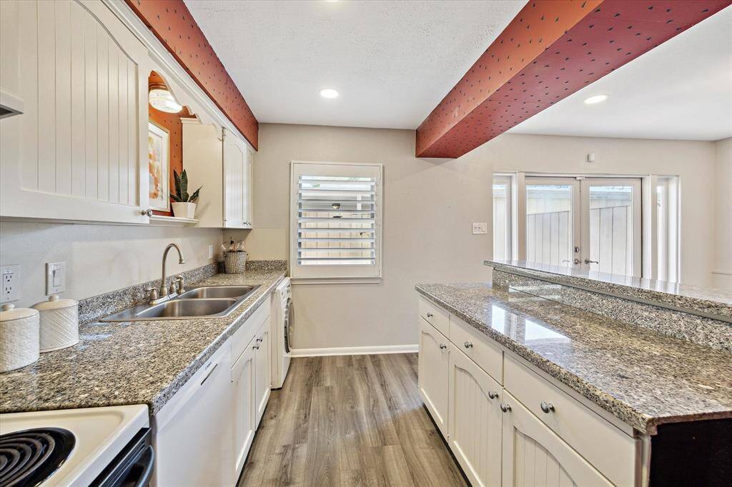 The kitchen offers ample counter space to prep your favorite meals and is bathed in natural light streaming through a large window, creating a bright and inviting atmosphere.