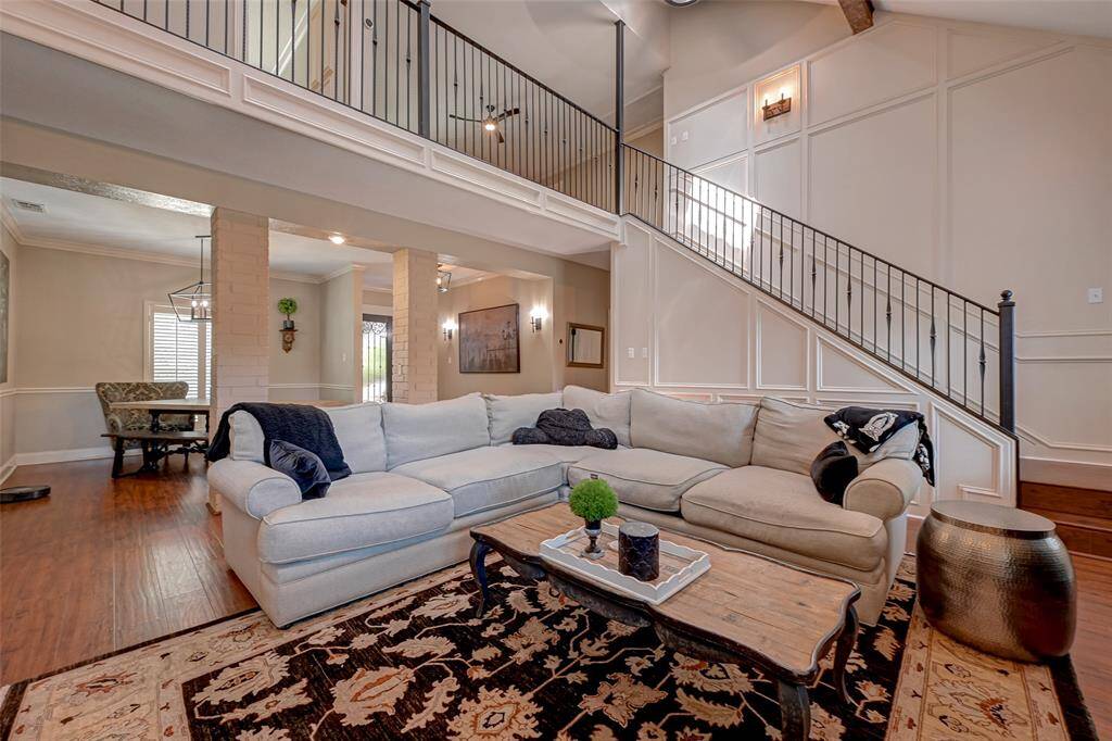 Opposite the painted brick columns, the dining area seamlessly transitions into the expansive living room, characterized by its vaulted ceiling that adds an airy and open feel to the space. As you ascend the staircase to the second floor, you'll notice the elegant touch of WROUGHT IRON SPINDLES (2020), which also grace the second-floor gameroom, enhancing the home's overall aesthetic.