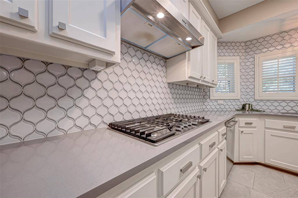 Equipped with a WHIRLPOOL 5-BURNER GAS COOKTOP (2020) and STAINLESS STEEL VENTHOOD (2020). This kitchen is designed for culinary enthusiasts and offers versatile cooking options.