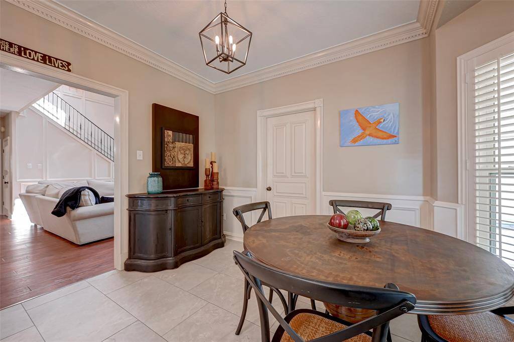 Breakfast room offers wall space ideal for a baker's rack or server, allowing for additional storage and display options. Crown molding adds a touch of sophistication, while half-wall picture frame molding along the lower portion of the wall enhances the room's aesthetic appeal. Notice the uniform updated lighting throughout the home. One striking feature to note is the consistent & UPDATED WROUGHT IRON LIGHTING FIXTURES that adorn the entire home, adding a cohesive & stylish element to its overall design.