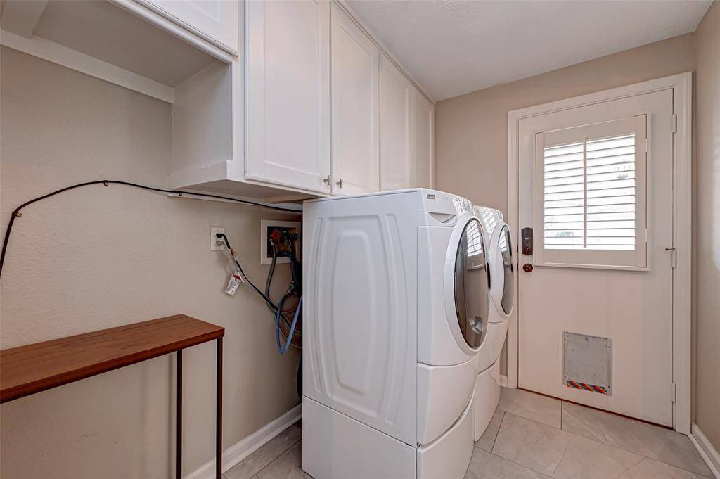 The utility room, measuring 9.3x6.7, offers ample space for a full-size washer and dryer, with a KENMORE ELITE WASHER & DRYER already included. It's thoughtfully plumbed with BOTH electric and gas dryer connections for your convenience. Upper storage cabinets provide additional organization options, and there's room for a second refrigerator or upright freezer. It also has a handy 2ND PANTRY for additional storage. Door leads to backyard and detached 4-car garage.