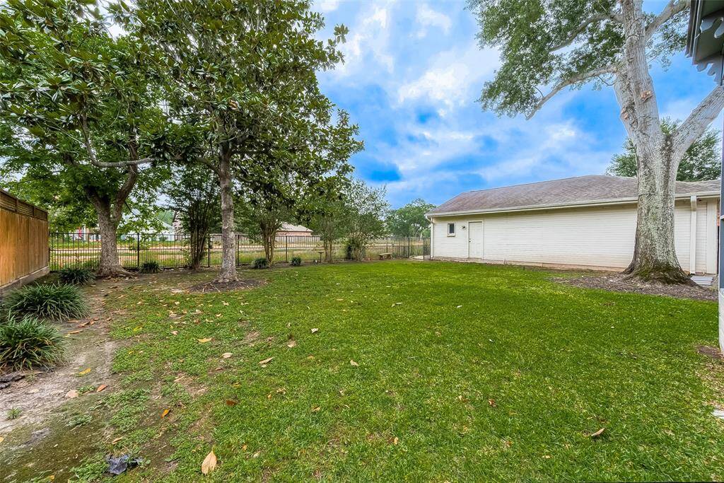 The backyard is completely enclosed by wood privacy fencing on the sides and wrought iron fencing along the back, providing a picturesque view of the bayou. This expansive space offers ample room for children and the family dog to run and play freely. Additionally, there's PLENTY OF SPACE FOR A SWIMMING POOL if that's a desired addition, making it a versatile outdoor haven for relaxation and recreation.