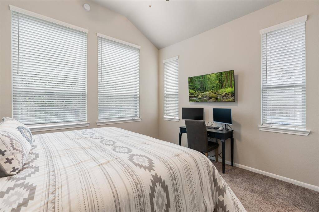Another view of the primary bedroom with the windows viewing the backyard.