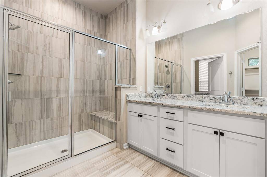 Large shower with seating in the primary bathroom.