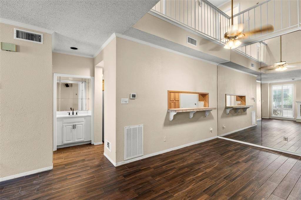 A view from the bottom of the stairs looking into the dining room and pass-through breakfast bar that leads into the kitchen. Notice how the room is open to the upstairs, creating a bright and airy ambience.