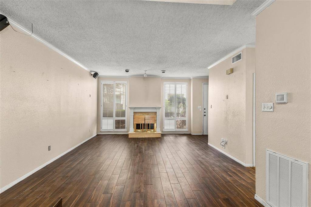 Looking back at the attractive fireplace and view to quiet courtyard through the floor to ceiling windows with plantation shutters.