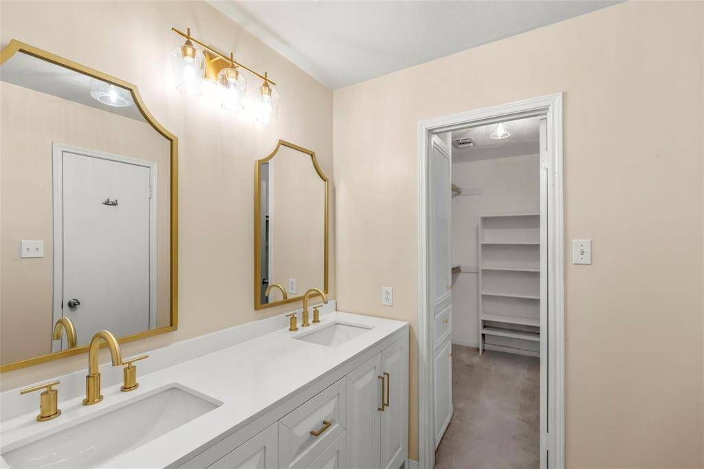 En suite #1 offers a double vanity with a large walk-in closet to the right.