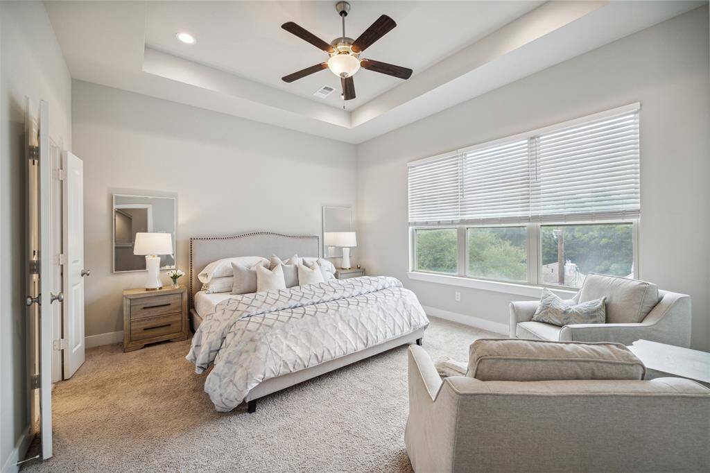 The primary suite is perched on the third floors with picturesque views of trees and city life! Enjoy tray ceilings, plush carpet and tray ceilings. *Home furnishings may differ*