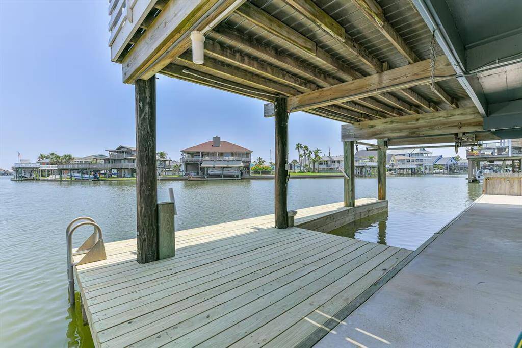 This photo showcases a waterfront property with a new private dock, providing direct access to a calm channel. Ideal for boating enthusiasts, the dock is sturdy and features covered areas, perfect for enjoying serene water views.  New boat dock, boat lift and fish cleaning table.