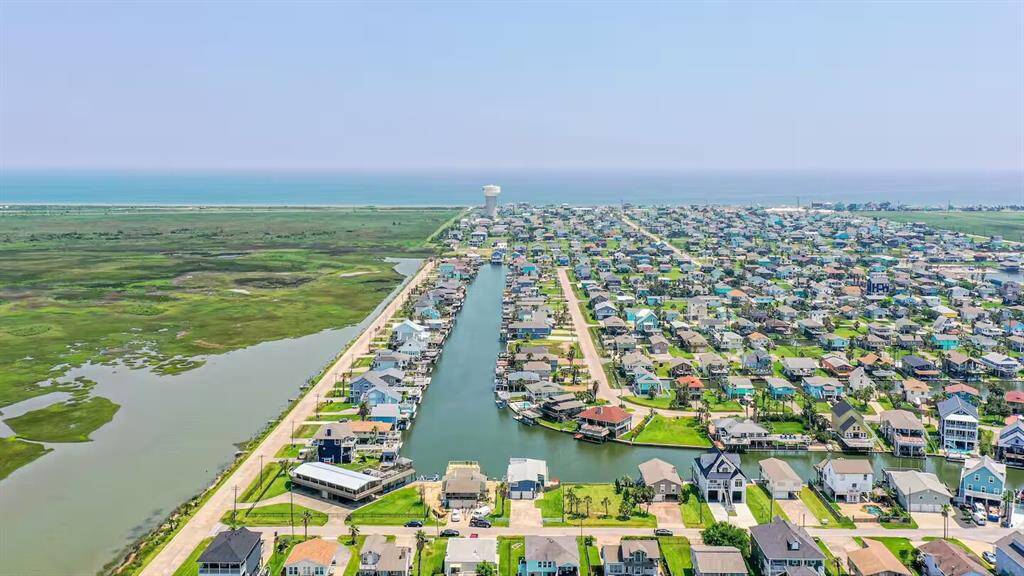 This photo shows a coastal neighborhood with a canal running through it, offering water access and scenic views.  Perfect for those seeking a waterfront lifestyle.