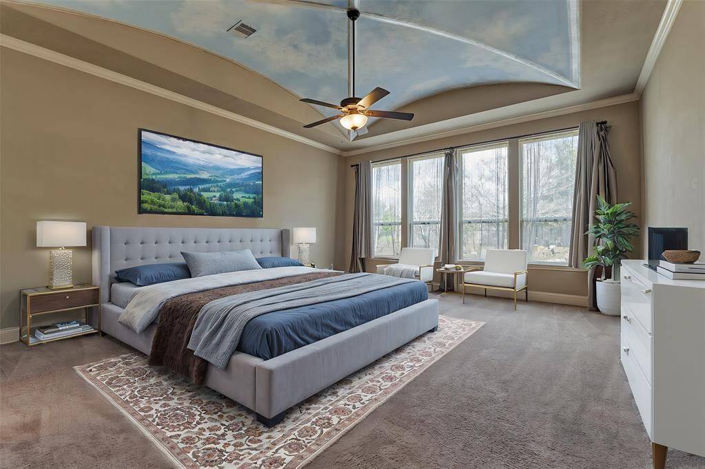 Primary suite is very spacious and features vaulted tray ceilings, crown molding and views of the backyard *virtually staged*