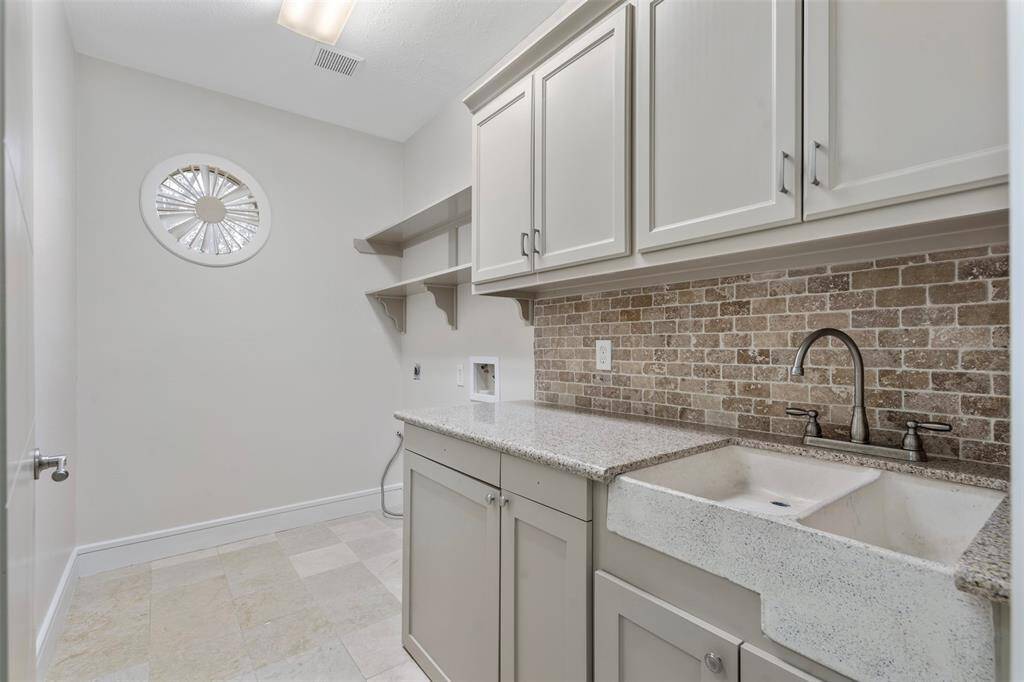 Imagine stress free laundry time here.  Complete with a wash/prep sink and plenty of cabinets and countertop.