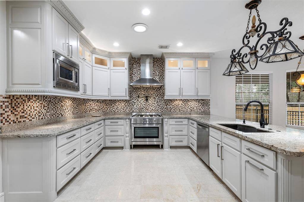 This gourmet kitchen is not for the faint of heart. With undermount lighting, to the ceiling cabinetry, pot filler, plenty of countertop space to work on, you can imagine your chef here doing their best work.
