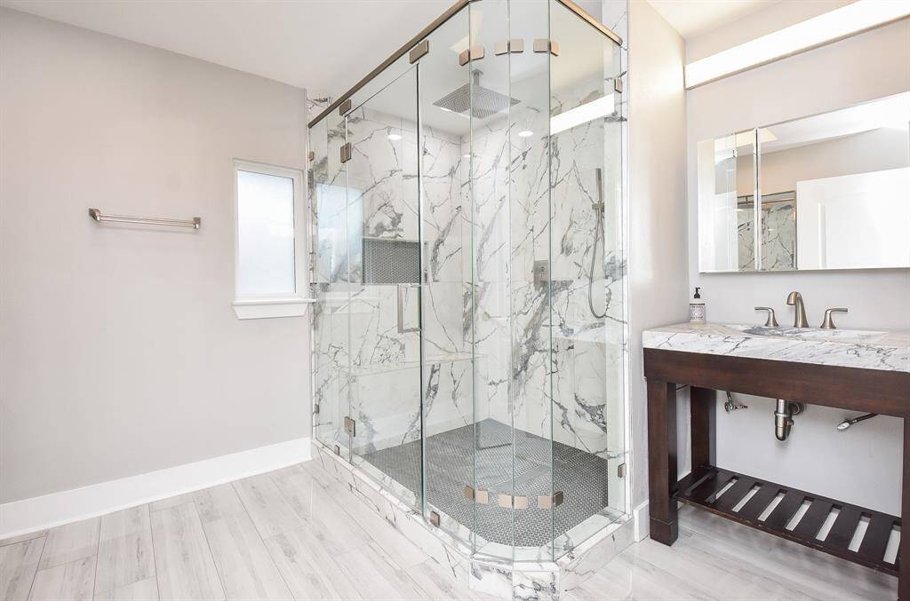 Experience the elegance of the secondary bath, featuring a sleek rimless shower and stylish vanity area.