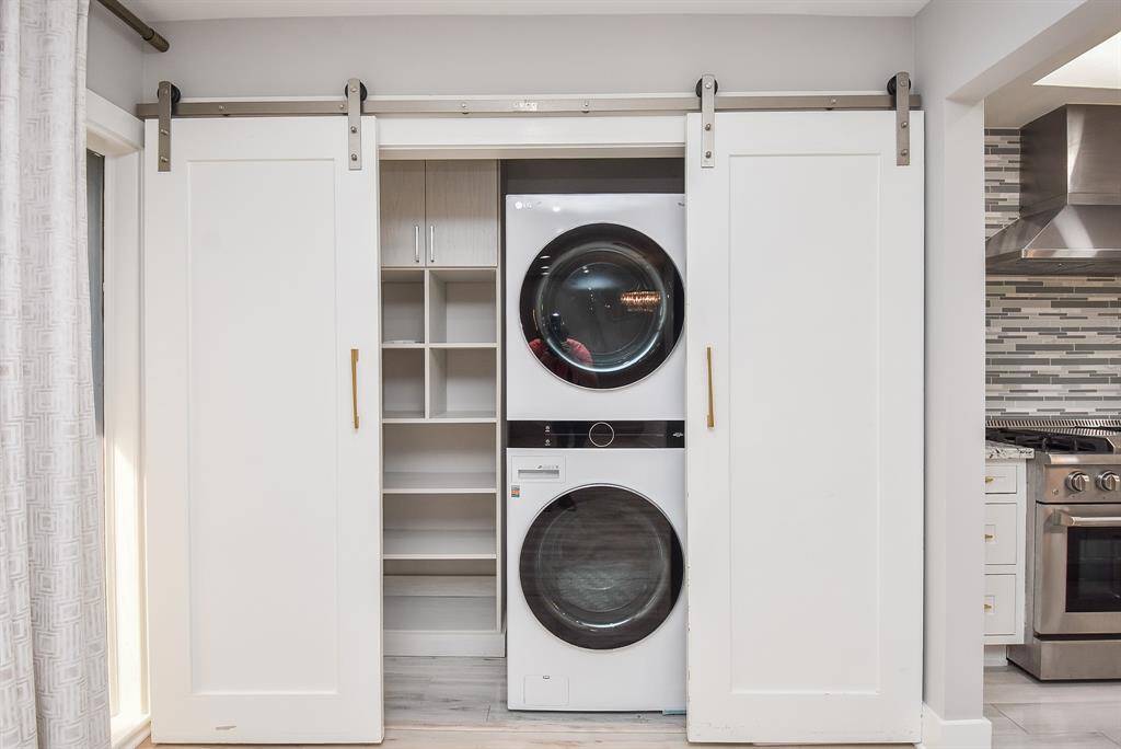 Modern laundry room featuring a full-sized stackable washer and dryer.