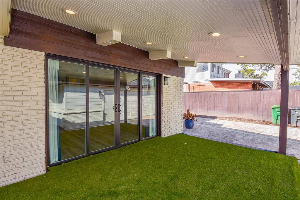 Discover a charming covered patio with artificial grass and recessed lighting, accessible through large sliding doors from the living area. Enjoy this private oasis with a view of the fenced backyard, perfect for relaxation or entertaining.