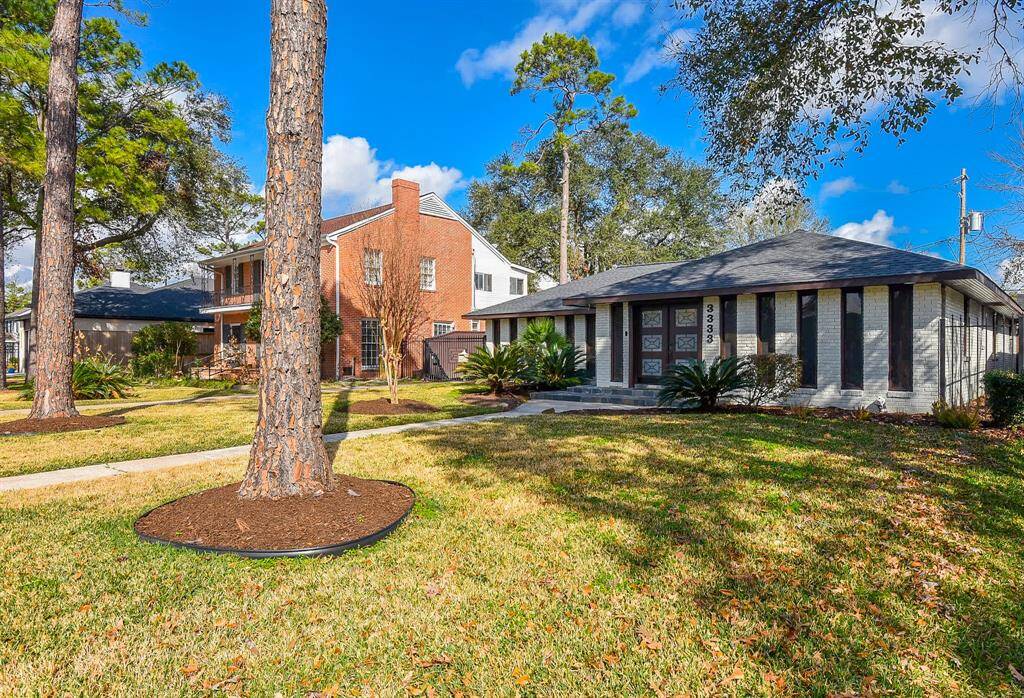 Charming front view with mature trees and a beautifully maintained yard.