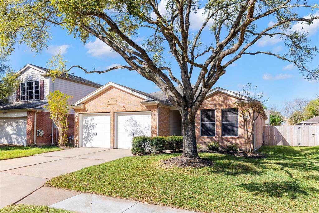 This charming home features a brick exterior with a two-car garage and a well-maintained lawn. A large tree provides shade to the front yard, enhancing curb appeal. Perfect for families seeking a welcoming neighborhood setting.