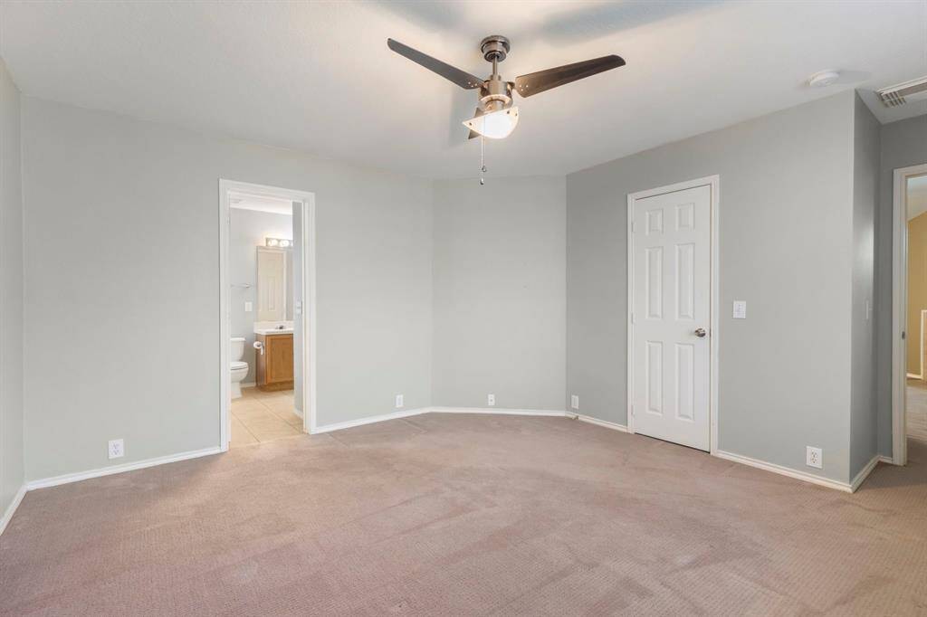 Spacious primary bedroom featuring an ensuite bathroom and ample natural light.