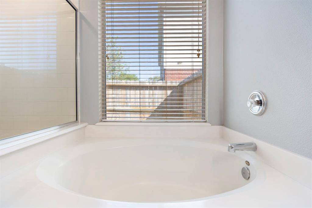 Luxurious primary bath featuring a serene soaking tub with a view.