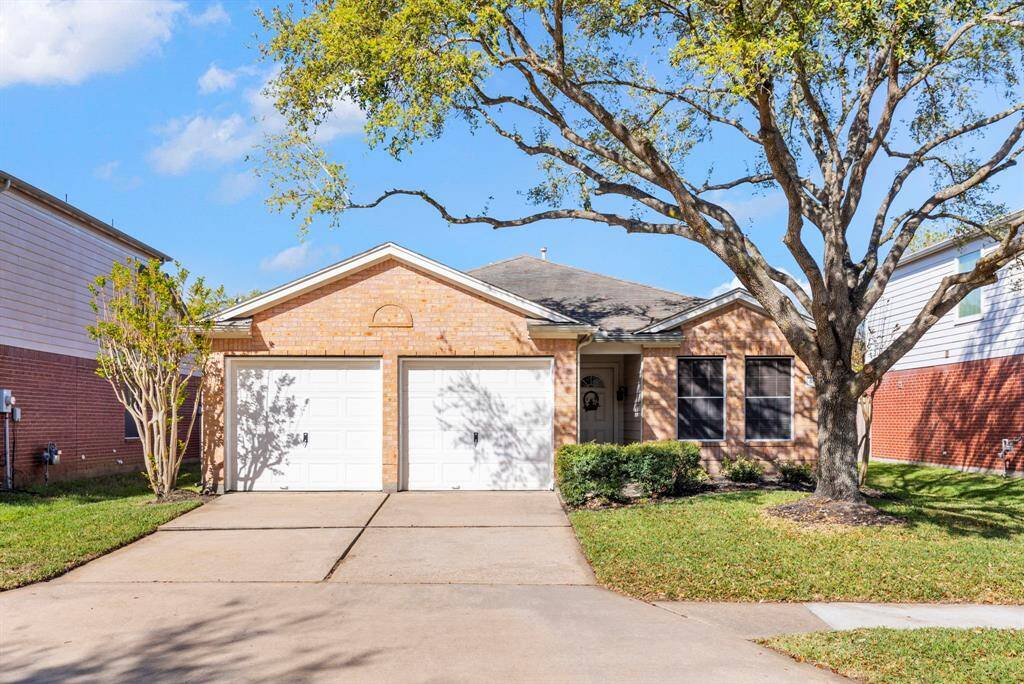 Charming single-story brick home with a two-car garage and a welcoming front yard. Features a large tree providing shade and a clean driveway. Ideal for those seeking a cozy and inviting neighborhood setting.