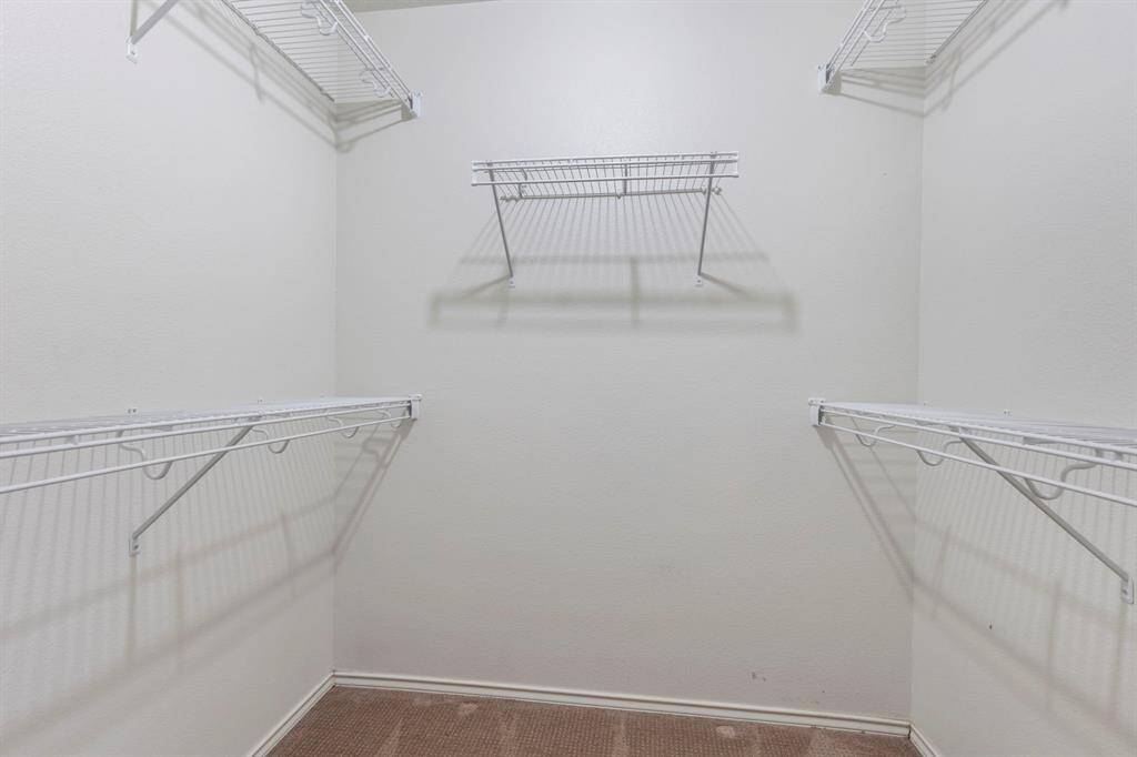 Spacious walk-in closet with ample shelving, perfect for organizing your wardrobe.