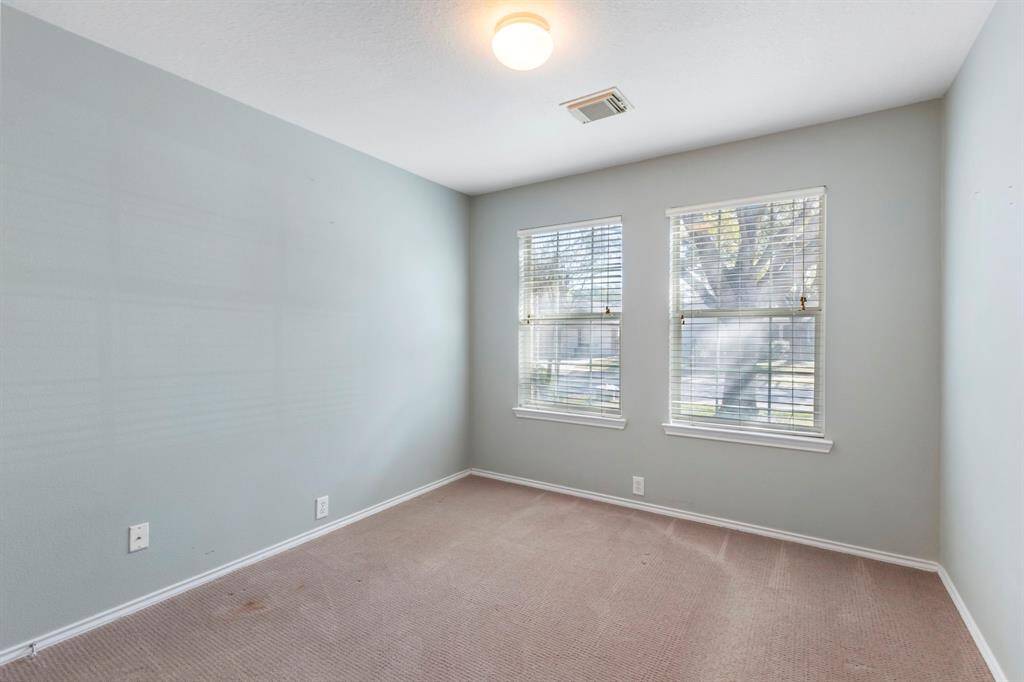 Bright and versatile third bedroom with ample natural light and cozy carpeting.