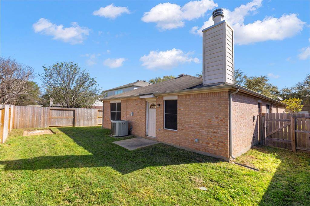 This photo shows a cozy brick home with a fenced backyard, chimney, and well-maintained lawn, perfect for outdoor activities.