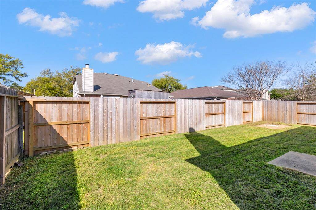 Spacious, sunny backyard with a well-maintained wooden fence, offering privacy and potential for landscaping or outdoor activities.