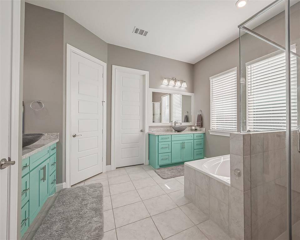 The primary bathroom has custom painted cabinets and upgraded sink bowls.