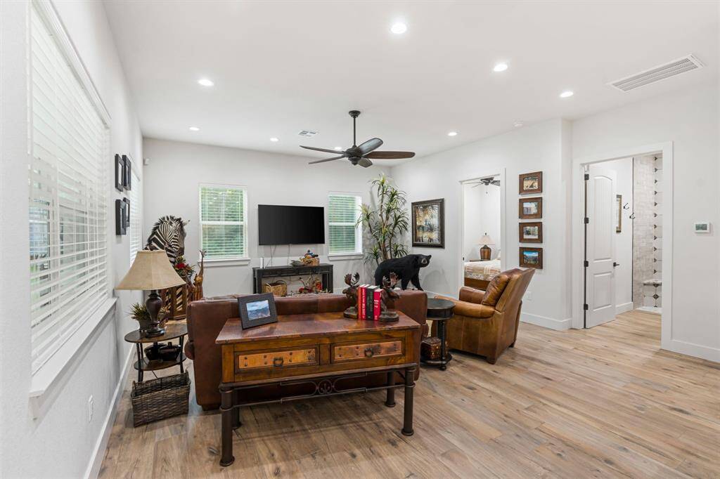 Living room features beautiful flooring, recessed lighting, ceiling fan, and large windows.