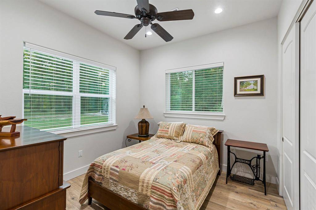 Secondary bedroom features  windows and ceiling fan.