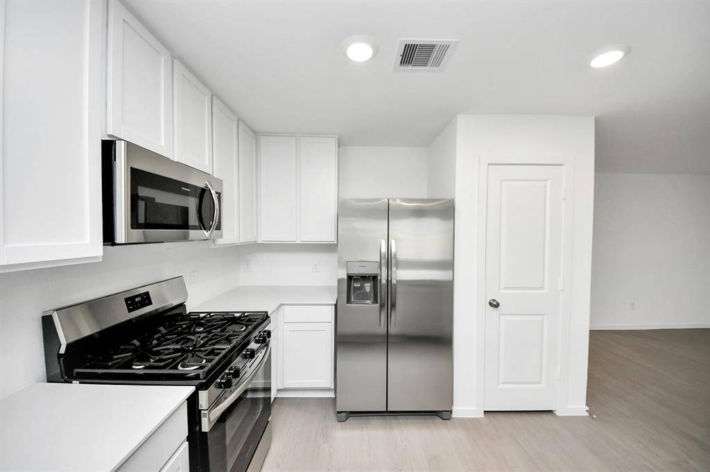 This beautifully designed kitchen features energy-saving stainless steel appliances, combining modern efficiency with sleek style.