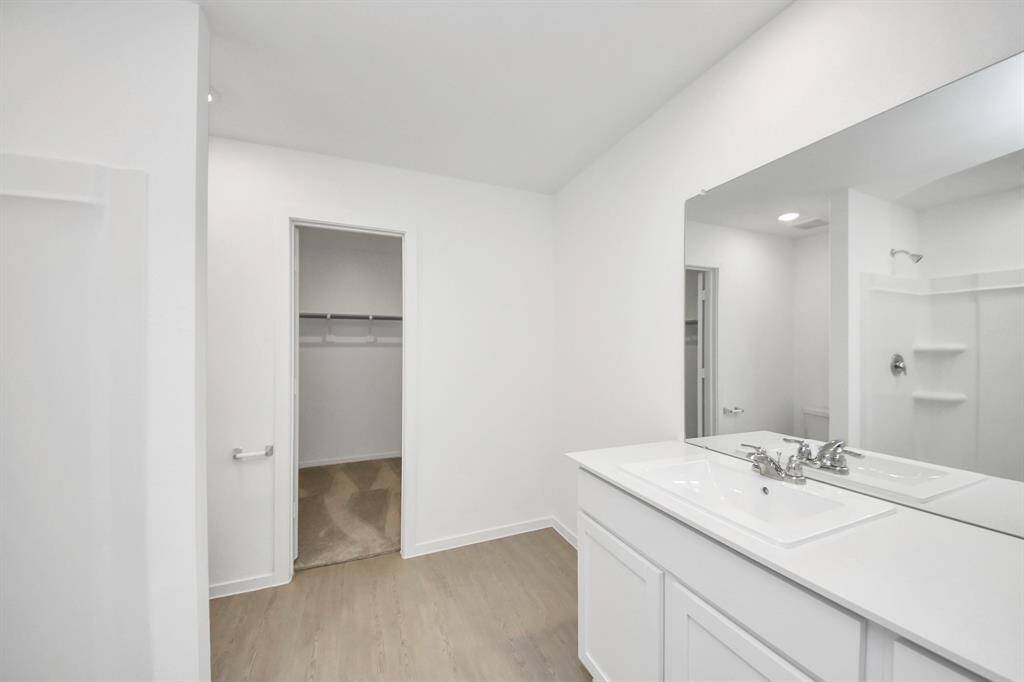 The ensuite bathroom offers a spa-like retreat, featuring elegant quartz countertops that add a touch of sophistication.