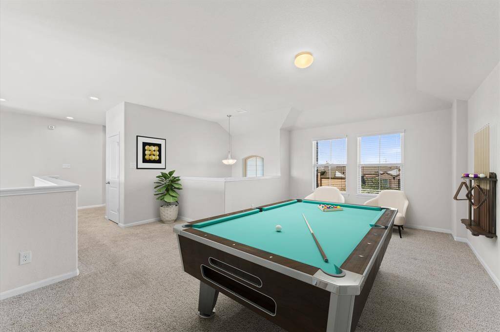 The upstairs game room is a versatile space, ideal for movie nights, game sessions, or simply lounging. Carpet flooring adds a warm, inviting touch, while the window provides a nice view of the outdoors.