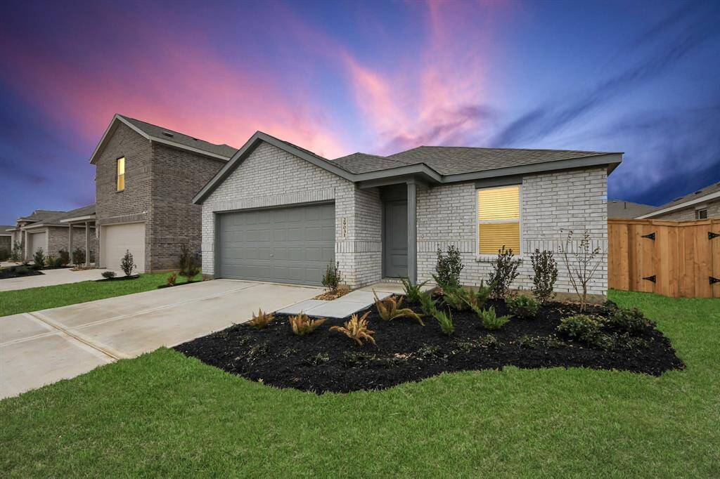 This charming single-story home features a modern brick exterior, a two-car garage, and a well-manicured front yard. Situated in a suburban setting, it offers a welcoming entrance and a beautiful sunset backdrop.