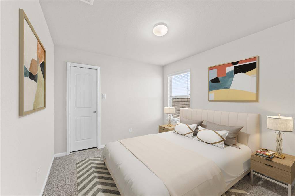 This second bedroom is bright and welcoming, with a window offering lovely views of the outdoors. Soft carpet flooring adds a cozy touch, making it an inviting space for rest or relaxation.