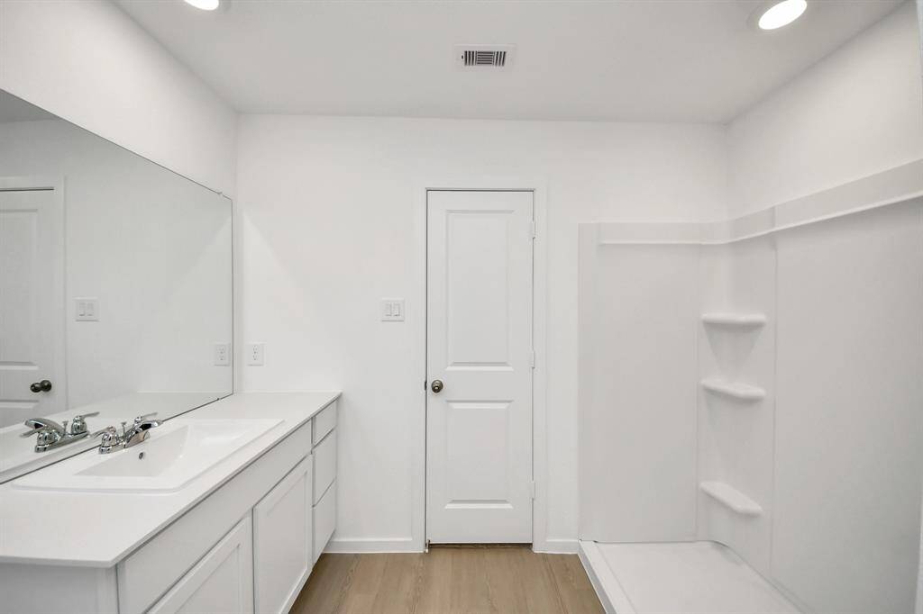A spacious vanity provides ample storage, while modern fixtures enhance both style and functionality.