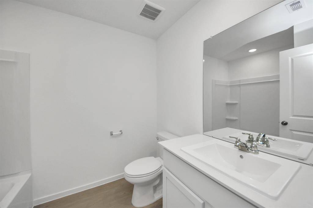 This bathroom features a minimalist design with a clean, white aesthetic.