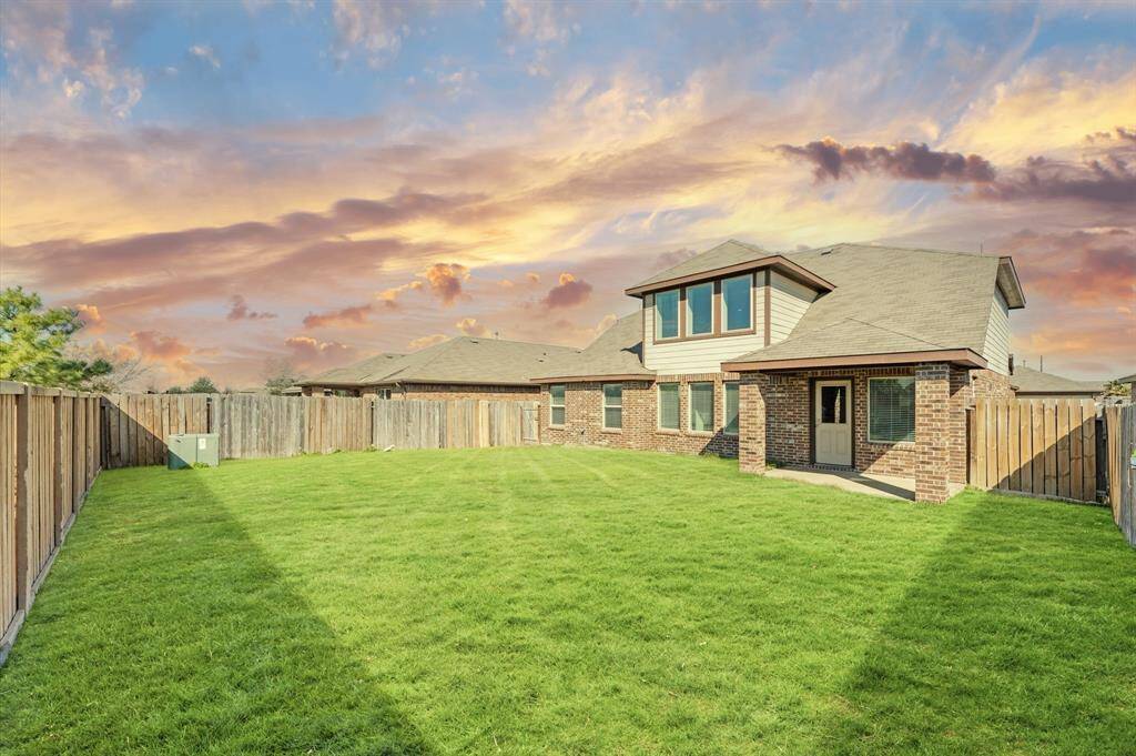 The backyard is a haven for outdoor living, featuring a spacious covered patio perfect for relaxing or entertaining.