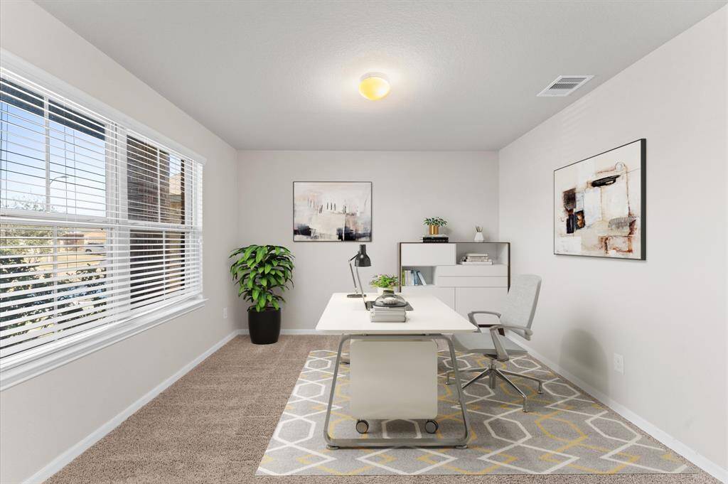 The study room is a quiet retreat, featuring soft carpet flooring and a wide window that lets in ample natural light.