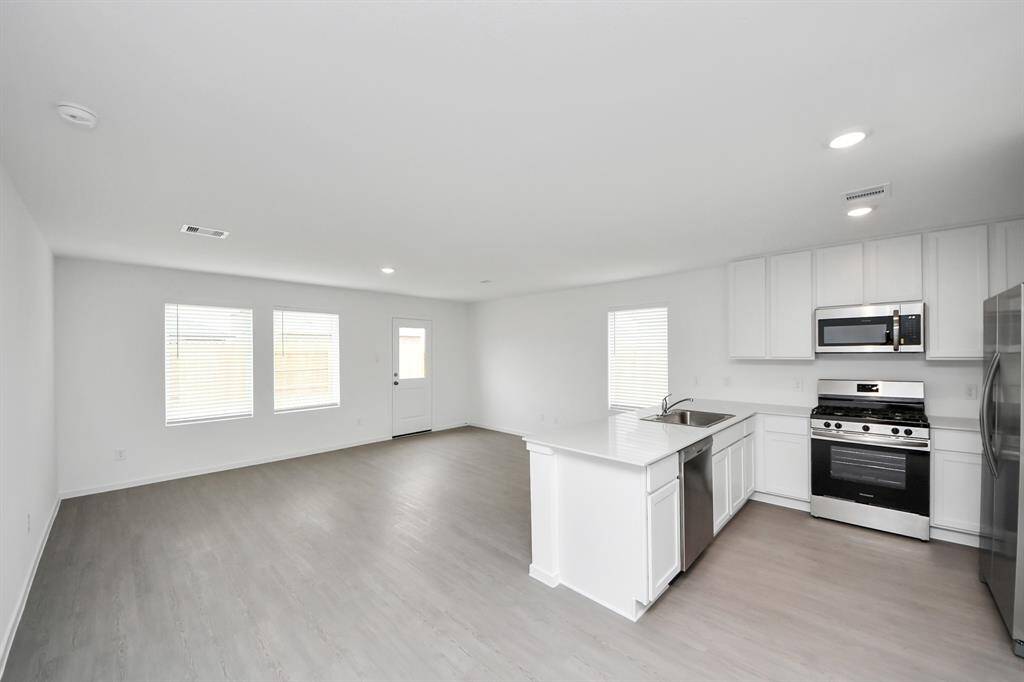 This open-concept kitchen seamlessly flows into the spacious living area, creating the perfect space for entertaining and everyday living.