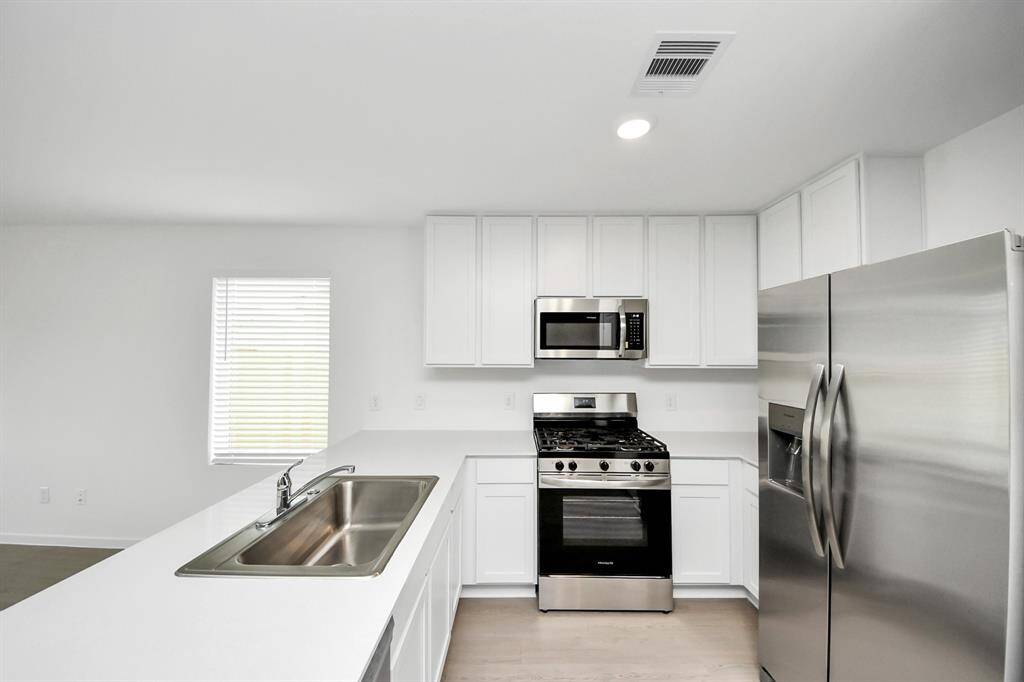 Featuring sleek countertops, modern appliances, and ample cabinetry, the kitchen is both stylish and functional.