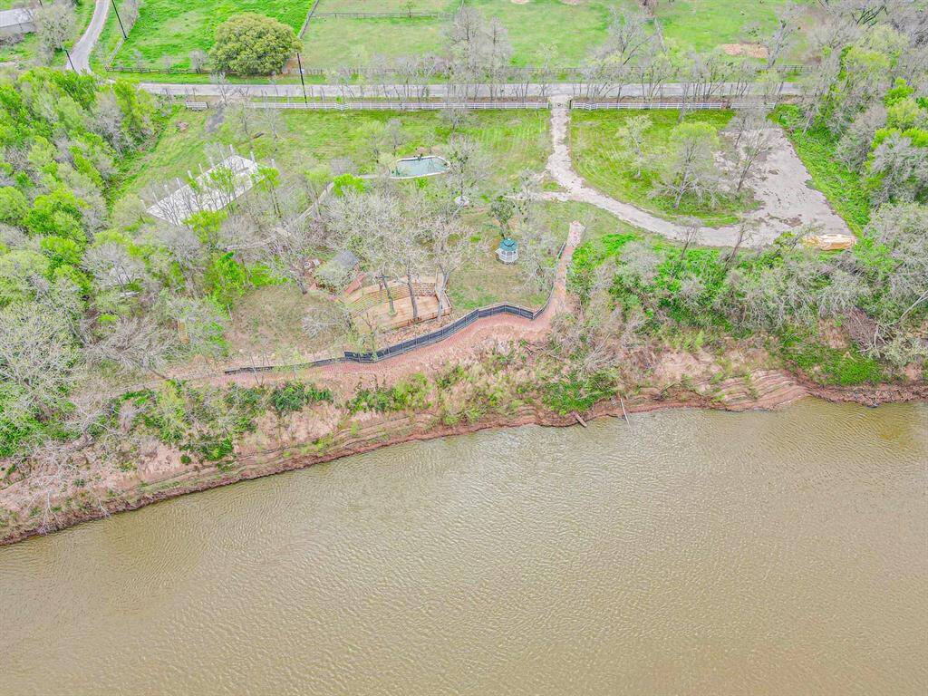 Experience breathtaking east-to-west aerial views of this serene riverside property, surrounded by lush greenery and tranquil open spaces.
