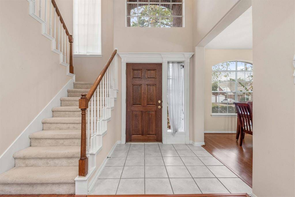 Tiled front entry with a high ceiling.