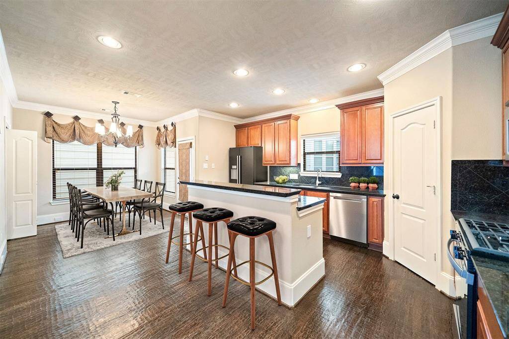 Discover the heart of your new home with a chef-inspired kitchen, boasting a spacious island with an integrated breakfast bar, elegant granite countertops, sleek stainless steel appliances, a chic wine fridge, and ample storage for a clutter-free culinary space. Please note, the staging is virtual to showcase the room's potential.