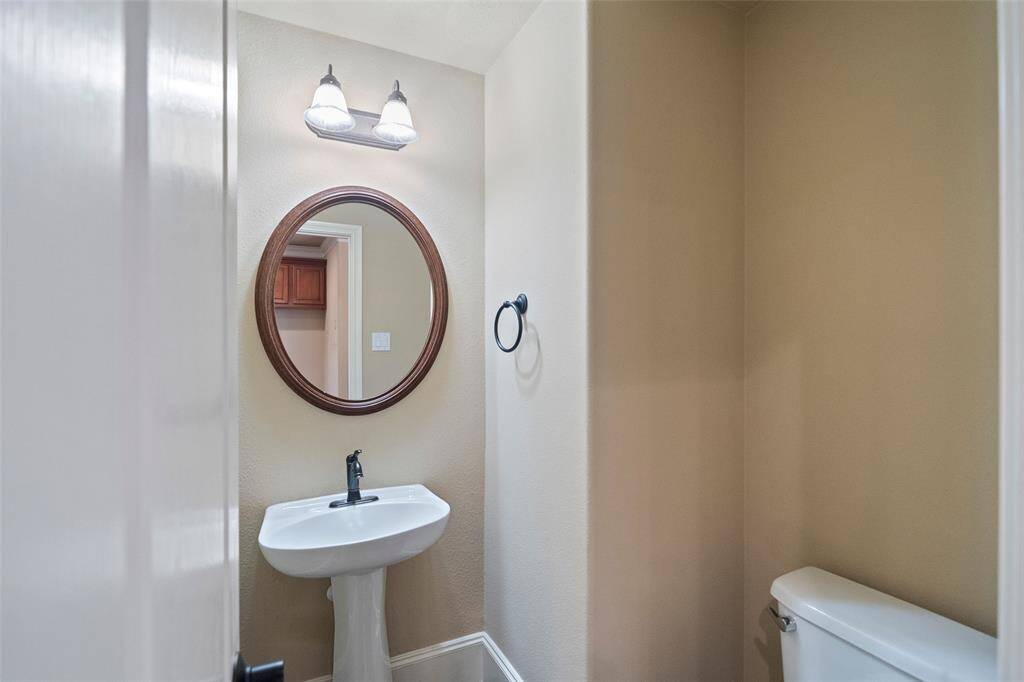Charming second-floor powder room with elegant fixtures.