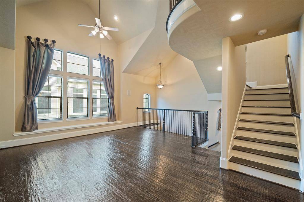 Discover the expansive living space bathed in natural light, complete with soaring ceilings and an elegant staircase ascending to the third level.